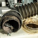 Black washing machine drain pipe with clog and mold. The concept of proper washing machine maintenance.