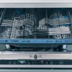 Dishwasher. Open dishwasher with clean utensils. Open dishwasher machine with clean cutlery set
